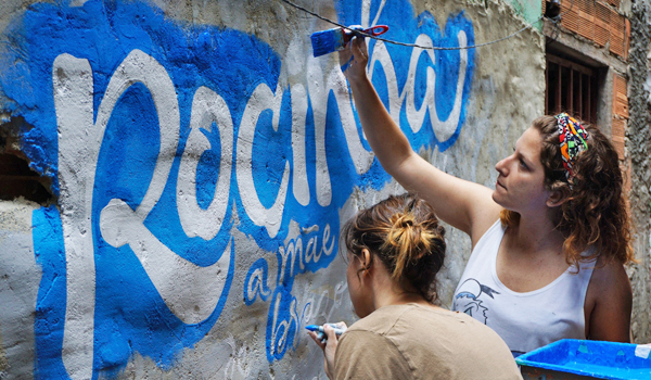 volunteer paints orphanage wall