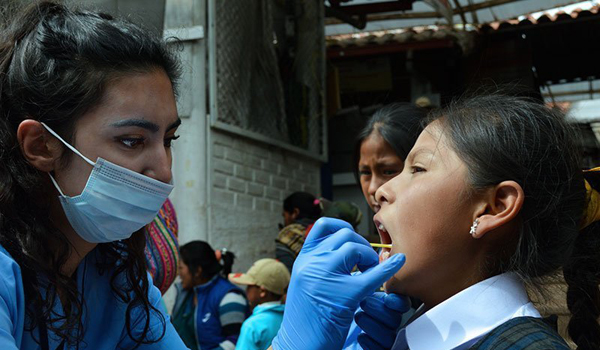 volunteer inspecting child teeth