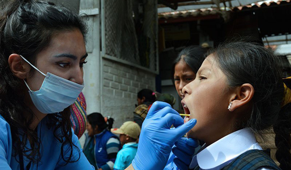 medical volunteer checking child teeth