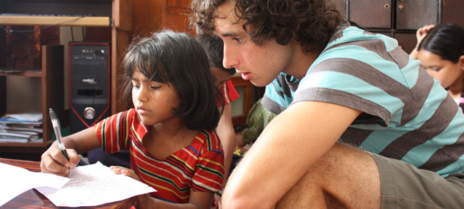 volunteers helping orphanage children with homework