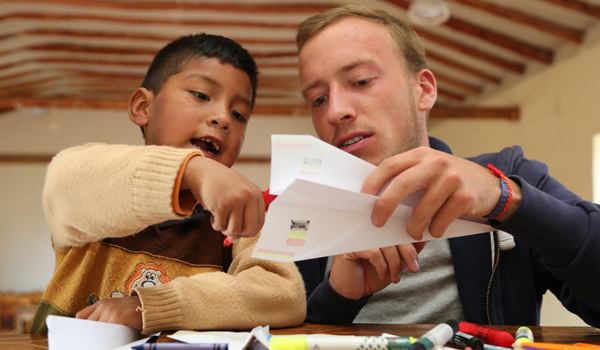 volunteer making paper plane for kids