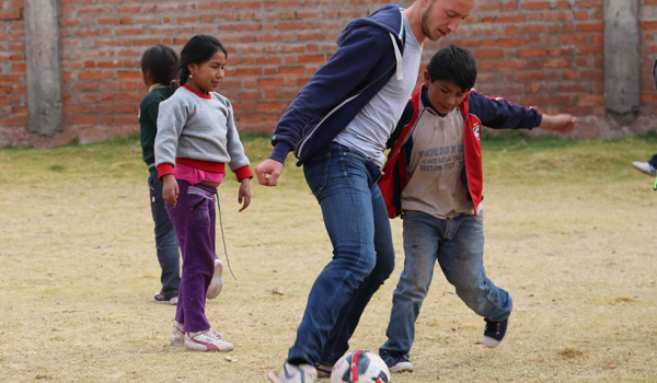 volunteer palying football with child