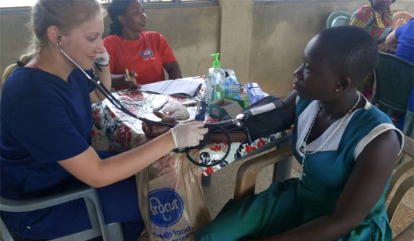 volunteer having a primary health checkup of patient in africa