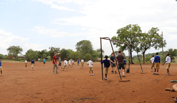 volunteer participating in game with school kids