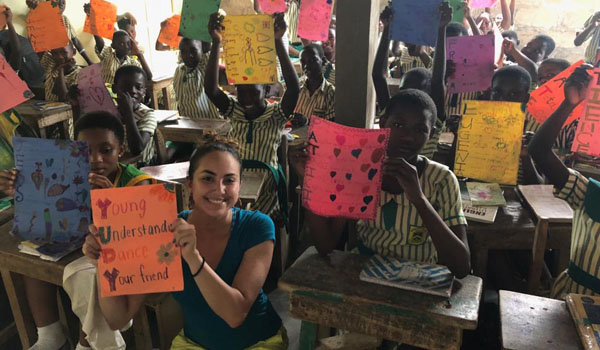 volunteer displaying cards with students